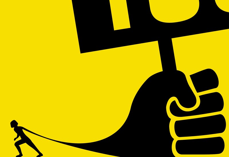 An activist drags a giant fist holding a banner